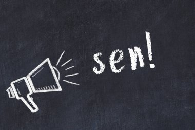 Hoparlörlerin tebeşir çizimi ve siyah masanın üzerine el yazısıyla yazılmış yazılar.