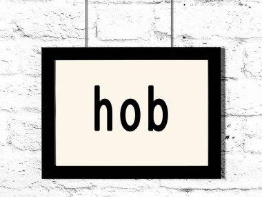 Siyah ahşap çerçeve, beyaz tuğla duvarda yazıtlar asılı. 