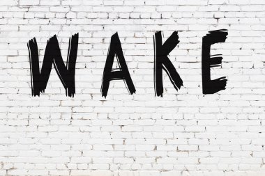 Yazılı beyaz tuğla duvar siyah boyayla yazılmış.