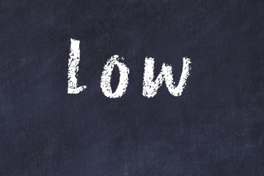 Tebeşir el yazısıyla yazılmış yazı siyah masanın altında.