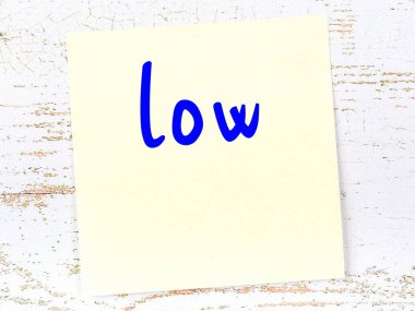 Düşük hakkında hatırlatma kavramı. Tahta duvarda üzerinde yazı olan sarı yapışkan kağıt.