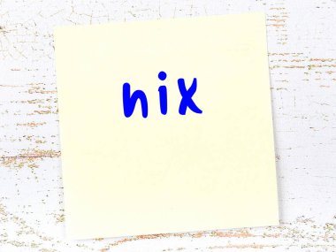 Tahta duvarda el yazısıyla yazılmış sarı yapışkan bir not var.