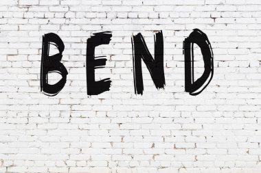 Yazı eğrisi beyaz duvara siyah boya ile yazılmış..