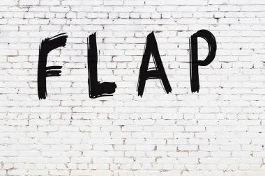 Üzerinde siyah boya bulunan beyaz tuğladan bir duvar.