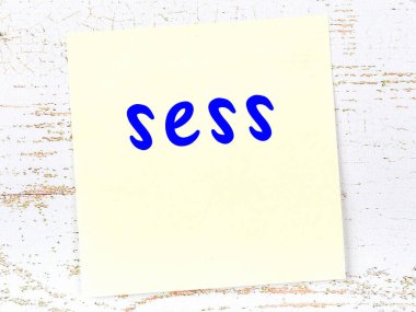 Değerlendirmeyi hatırlatma kavramı. Tahta duvarda üzerinde yazı olan sarı yapışkan kağıt.