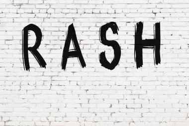 Üzerinde siyah boya olan beyaz tuğla bir duvar.