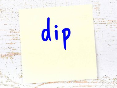 Tahta duvarda el yazısıyla yazılmış sarı yapışkan bir not var.