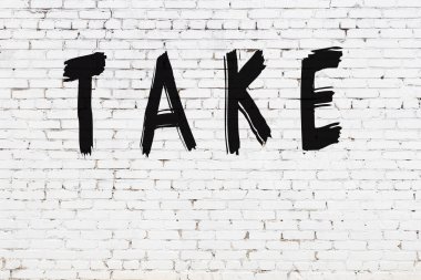 Üzerinde yazı olan beyaz tuğla duvar siyah boyayla el yazısını alır.