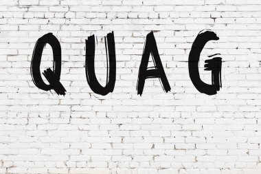Yazıt quag beyaz tuğla duvara siyah boya ile yazılmış.