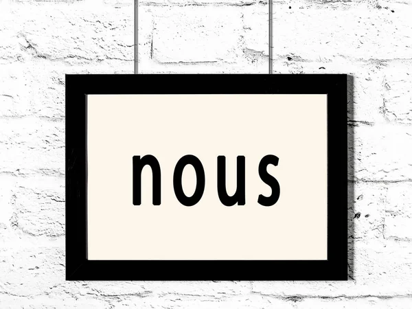 Black Wooden Frame Inscription Nous Hanging White Brick Wall — Stock Photo, Image