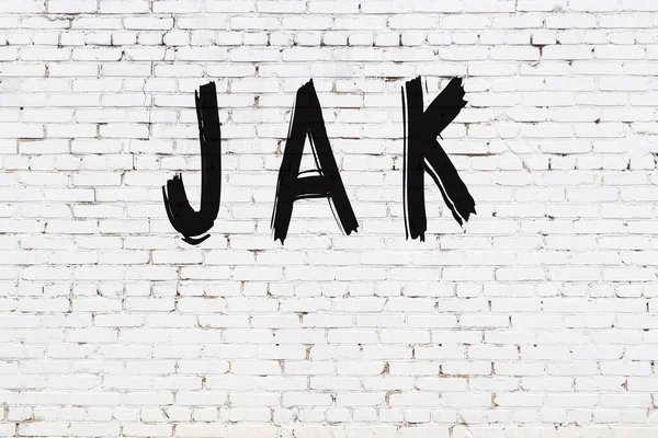 ブラックペイントで手書きの碑文ジャックとホワイトレンガの壁 — ストック写真