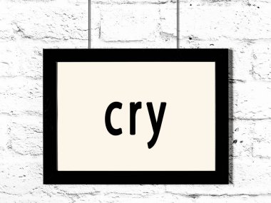 Üzerinde yazı olan siyah ahşap çerçeve beyaz tuğla duvarda asılı haykırıyor 