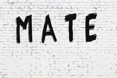 Üzerinde siyah boya olan beyaz tuğla bir duvar.