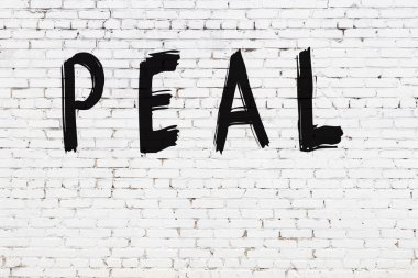 Yazı kabuğu beyaz tuğla duvara siyah boya ile yazılmış..