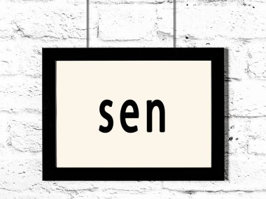 Siyah ahşap çerçeve beyaz tuğla duvarda sen yazılısın. 