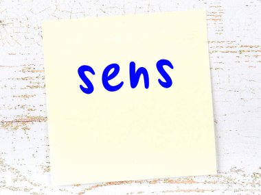 Duyular hakkında hatırlatma kavramı. Tahta duvarda üzerinde yazı olan sarı yapışkan kağıt.