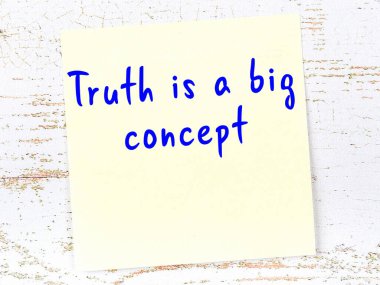 Tahta duvarda el yazısı motivasyon alıntısı olan sarı yapışkan not