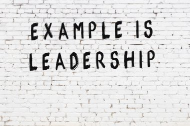 Üzerinde mantıklı alıntıların yazılı olduğu siyah boyanmış beyaz tuğla duvar.