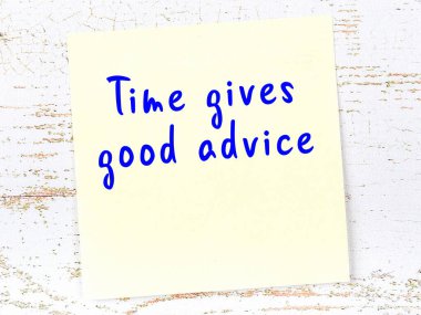 Sarı yapışkan not, ahşap duvarda el yazısıyla yazılmış zekice bir alıntıyla.