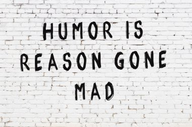 Beyaz tuğla duvar ve bilgece alıntıların yazılı olduğu siyah yazı.