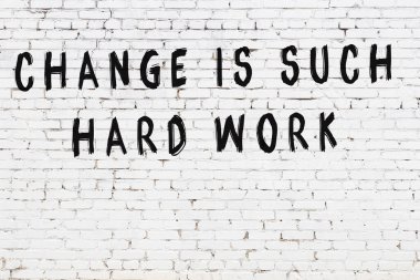 Üzerinde mantıklı alıntıların yazılı olduğu siyah boyanmış beyaz tuğla duvar.