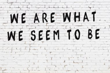 Beyaz tuğla duvar ve bilgece alıntıların yazılı olduğu siyah yazı.