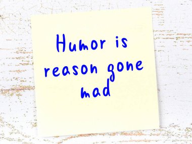 Tahta duvarda el yazısı motivasyon alıntısı olan sarı yapışkan not