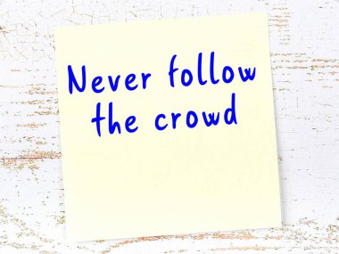 Tahta duvarda asılı sarı yapışkan nota elle yazılmış bilgece bir alıntı.