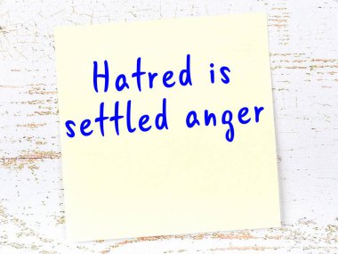 Sarı yapışkan not, ahşap duvarda el yazısıyla yazılmış zekice bir alıntıyla.