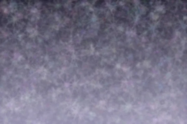 明るい灰色から濃い灰色の抽象的な背景に星形のボケスポットがあります — ストック写真