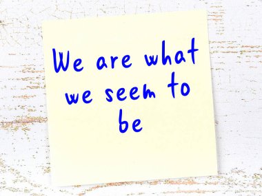 Tahta duvarda el yazısı motivasyon alıntısı olan sarı yapışkan not