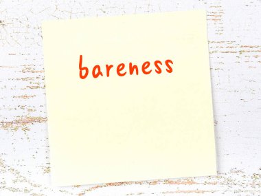 Erkekliği hatırlatan kavram. Tahta duvarda üzerinde yazı olan sarı yapışkan kağıt.