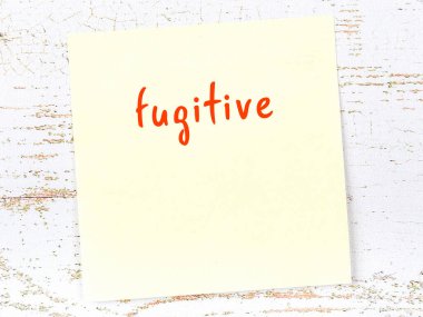 Ahşap duvarda sarı yapışkan bir not ve el yazısıyla yazılmış bir kaçak.