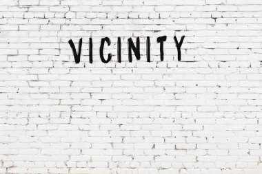 Üzerinde siyah boya bulunan beyaz tuğla bir duvar.