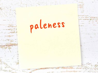 Tahta duvarda, el yazısıyla yazılmış solgunluğu olan sarı yapışkan bir not.