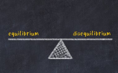 Denge ve dengesizlik arasındaki denge kavramı. Üzerinde pullar ve kelimeler olan siyah bir karatahta.