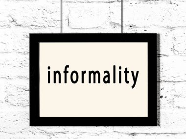 Beyaz tuğla duvarda asılı siyah ahşap çerçeve ve gayri resmi yazı. 