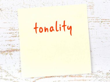 Tonlama hakkında hatırlatma kavramı. Tahta duvarda üzerinde yazı olan sarı yapışkan kağıt.