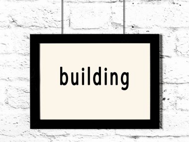 Beyaz tuğla duvara asılı siyah ahşap çerçeve. 