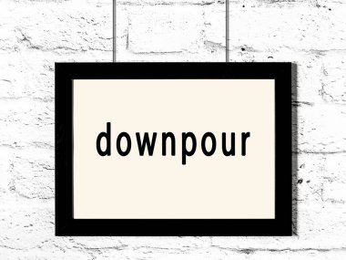 Beyaz tuğla duvara asılı siyah ahşap çerçeve ve yazı sağanağı 