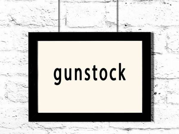 Moldura Madeira Preta Com Inscrição Gunstock Pendurado Parede Tijolo Branco — Fotografia de Stock