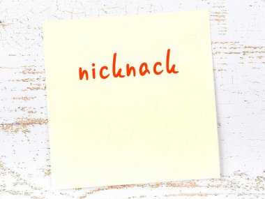 Niknack 'i hatırlatma kavramı. Tahta duvarda üzerinde yazı olan sarı yapışkan kağıt.