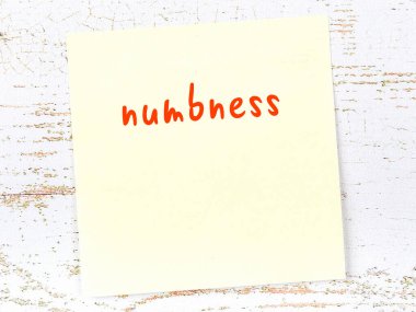 Tahta duvardaki sarı yapışkan notta el yazısıyla yazılmış uyuşukluk var.