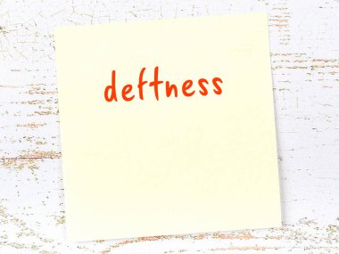 Tahta duvarda el yazısıyla yazılmış kusurlu sarı yapışkan bir not var.