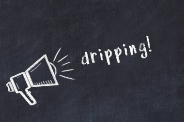 Hoparlörün tebeşir çizimi ve siyah masaya damlayan el yazısıyla yazılmış yazı.