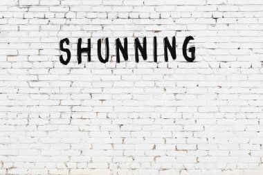 Yazı, beyaz tuğla duvara siyah boya ile yazılmış..