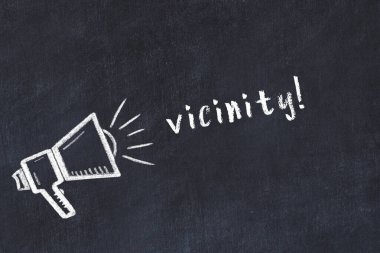 Hoparlörün tebeşir çizimi ve siyah masanın üzerine el yazısıyla yazılmış yazı.