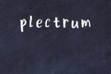 Tebeşir el yazısıyla yazılmış yazı plectrum siyah masada.