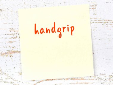 Tahta duvarda el yazısıyla yazılmış sarı yapışkan bir not var.