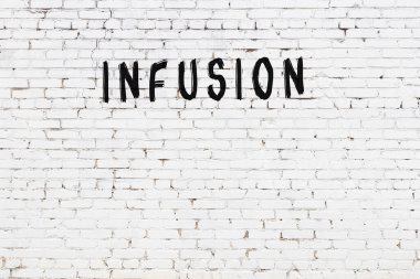 Beyaz tuğla duvara siyah boya ile yazılmış..